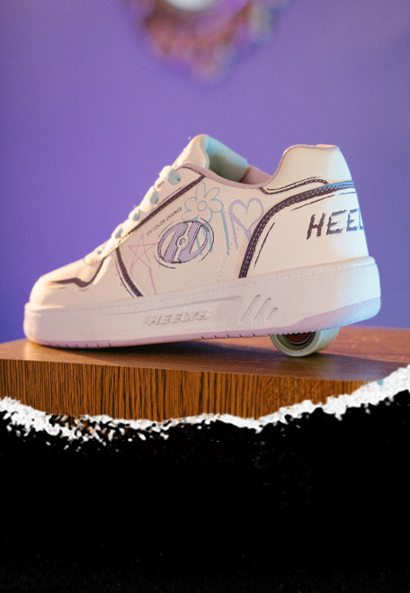 1 wheel Heelys roller shoes, White one wheel Heelys wheeled shoe with decorative elements on a wooden block against a purple background